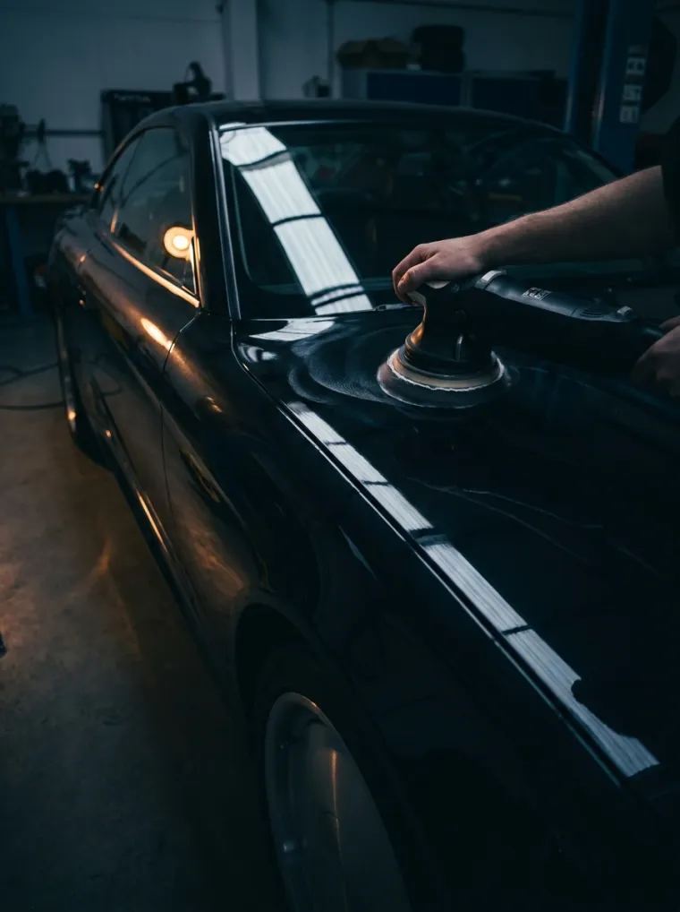 A polisher being worked across a car bonnet